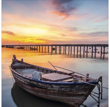 Bateau en bois sur le rivage avec une jetée en arrière-plan
