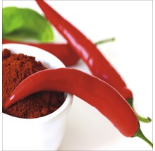 Chilipulver in einer Schale mit frischen Chilischoten