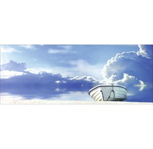 Boot am Strand unter blauem Himmel mit Wolken