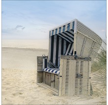 Fauteuil de plage en osier avec coussins rayés sur la plage