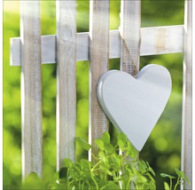 Cœur décoratif en bois accroché à une clôture de jardin