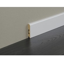 Weisse Sockelleiste aus Holz an einer Wand und einem dunklen Holzboden
