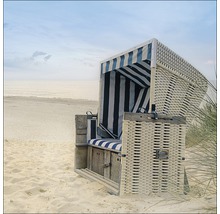 Fauteuil de plage en rotin avec revêtement en tissu rayé sur la plage