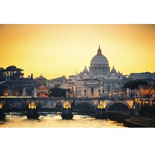 Vue sur la basilique Saint-Pierre à Rome au lever du soleil, avec pont et rivière au premier plan.