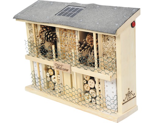 Hôtel à insectes en bois avec panneau solaire et divers matériaux de remplissage pour favoriser les insectes
