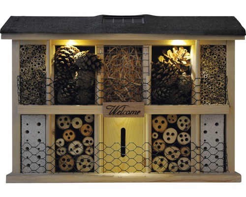 Hôtel à insectes en bois avec divers matériaux de remplissage tels que de la paille, des pommes de pin et des morceaux de bois