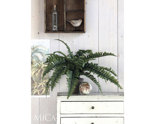 Dekorative Kunstpflanze auf einer Kommode mit Schubladen