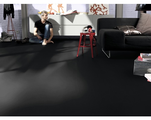 Salon avec sol vinyle foncé, canapé et homme assis