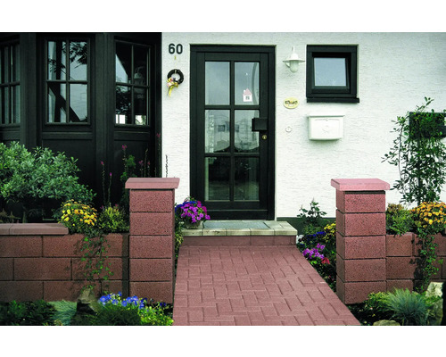 Zone d''entrée d''une maison avec des pavés, des bacs à plantes et une porte d''entrée