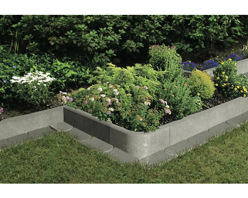 Beeteinfassung aus Beton mit Bepflanzung im Garten.