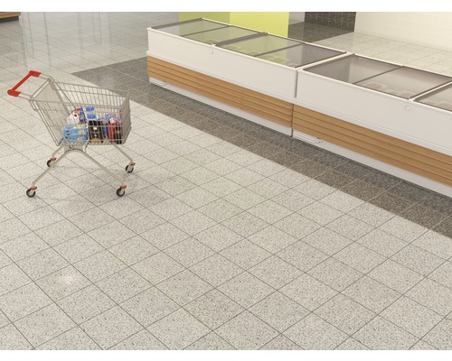 Einkaufswagen gefüllt mit Produkten neben einer Kühltheke im Supermarkt.