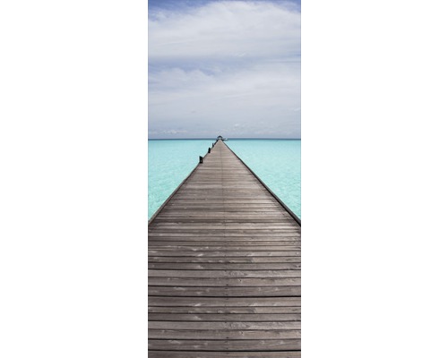 Holzsteg über türkisfarbenes Wasser unter einem hellen Himmel.
