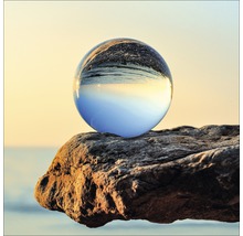 Dekorative Glaskugel auf einem Felsen am Meer