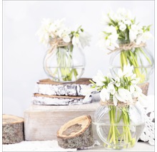 Trois vases en verre avec des perce-neige sur des rondelles de bois