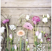 Arrangement floral avec des roses, des lisianthus et des gerberas sur fond de bois