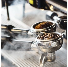 Siebträger einer Espressomaschine mit Kaffeebohnen und Kaffeepulver