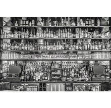 Eine Bar mit zahlreichen Getränkeflaschen auf Regalen und einer Theke.