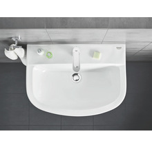 Aufsicht auf ein Waschbecken mit Armatur, Handtüchern, Seife und Spender