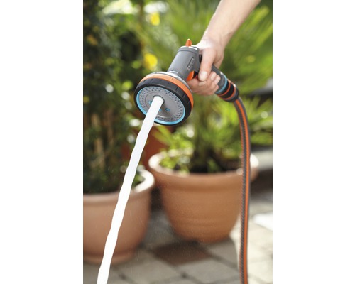 Person hält eine Gardena Mehrzweck-Brause mit Wasserstrahl