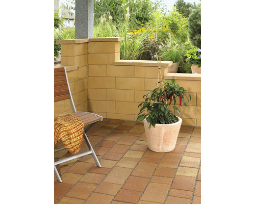 Terrasse mit Pflastersteinen, Mauer, Stuhl und Topfpflanze