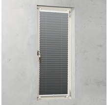 Store plissé gris sur une fenêtre pour le contrôle de la lumière