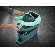 Une opératrice assemble un seau à vadrouille avec essoreuse pour le nettoyage des sols