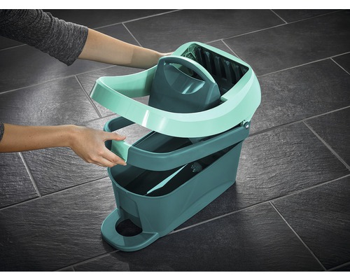 Une opératrice assemble un seau à vadrouille avec essoreuse pour le nettoyage des sols