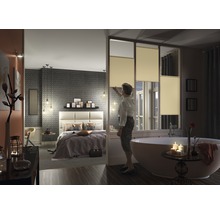 Helles Schlafzimmer und Badezimmer mit Plissee-Fenstern, getrennt durch eine Trennwand.
