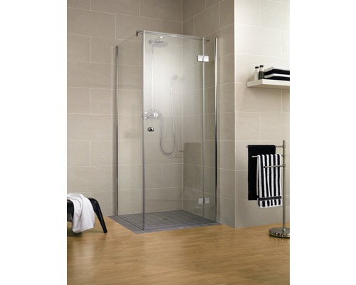 Cabine de douche avec portes en verre et robinetterie dans la salle de bain
