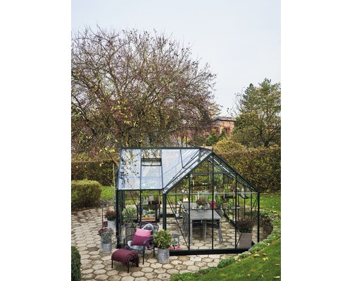 Gewächshaus mit Tisch und Stühlen im Garten