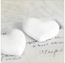 Deux coeurs en papier blanc sur du papier