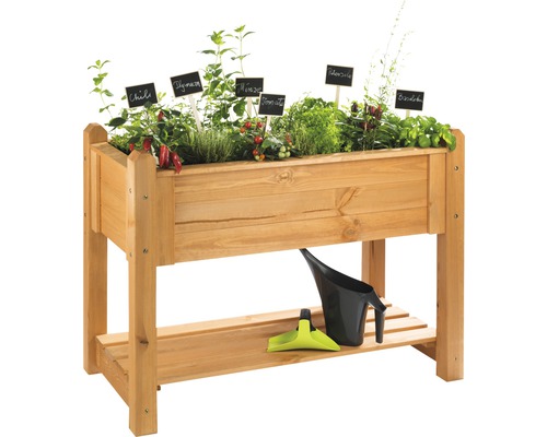 Jardinière surélevée en bois avec herbes aromatiques et légumes, ainsi qu''un arrosoir et une pelle