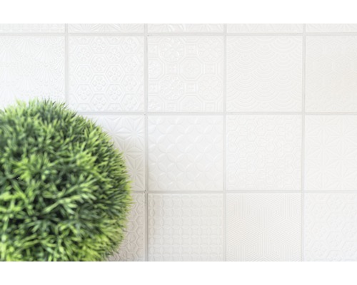 Helle Fliesen mit Muster und Topfpflanze