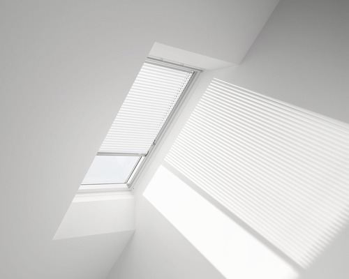 Fenêtre de toit avec store plissé dans une pièce lumineuse