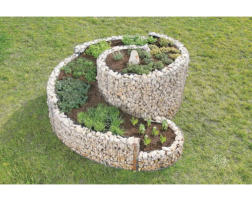 Kräuterspirale aus Steinen mit verschiedenen Kräutern