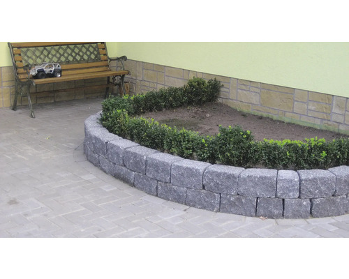 Bordure de parterre en pierre naturelle avec plantation dans le jardin.