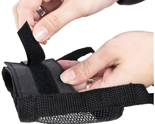 Gros plan d''une personne fixant une muselière avec fermeture Velcro.