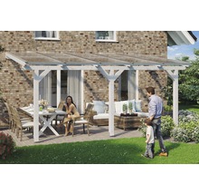 Überdachte Terrasse mit Terrassenmöbeln und Familie vor einem Backsteinhaus