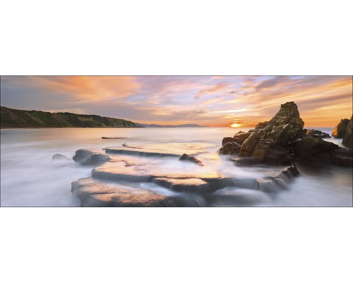 Paysage avec rochers, eau et coucher de soleil