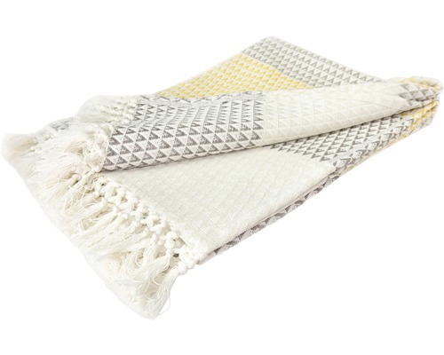 Couverture en textile pliée avec des franges et un motif géométrique