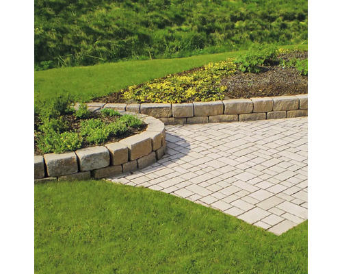 Garten mit Pflastersteinen und Natursteinmauer