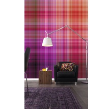 Ein Wohnzimmer mit einer gemusterten Tapete, einem Sessel, einer Stehlampe und einem Teppich.