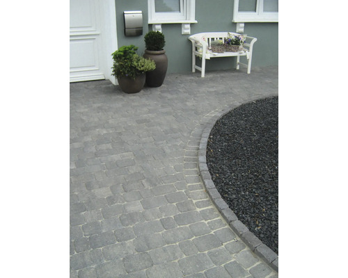 Außenaufnahme eines Hauses mit gepflastertem Gehweg und Zierkies