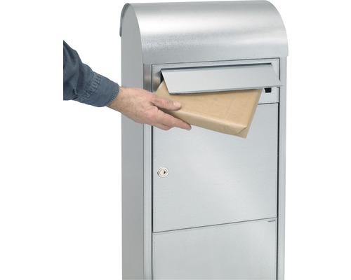 Freistehender Briefkasten aus Metall mit einer Person, die eine Sendung einwirft