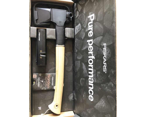 Hache Fiskars dans une boîte ouverte avec des accessoires