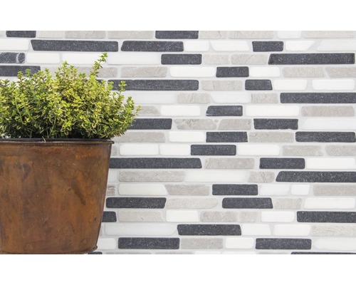 Mauer aus Mosaikfliesen mit Pflanze im Topf