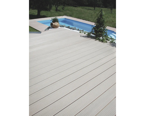 Planches de terrasse en bois à côté d''une piscine dans le jardin.