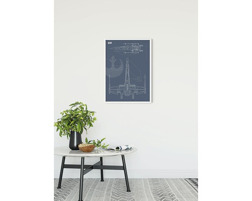 Tableau mural encadré avec le plan du Star Wars X-Wing sur une table