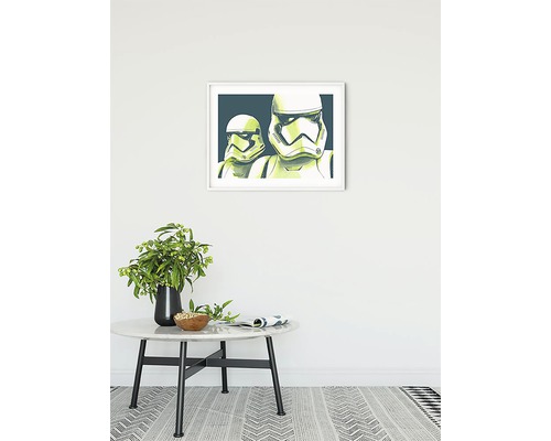 Dekoratives Bild mit Star Wars Stormtroopern im Rahmen an einer Wand über einem Tisch mit einer Vase.