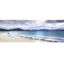 Vue de paysage avec plage de sable, mer et montagnes sous un ciel nuageux